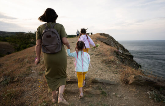 back-view-of-mother-and-children-walking-on-cliff-2023-11-27-04-50-01-utc