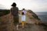 back-view-of-mother-and-children-walking-on-cliff-2023-11-27-04-50-01-utc